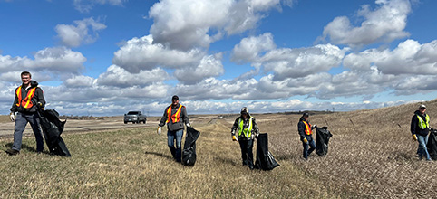 Employees cleaning up garbage in a ditch