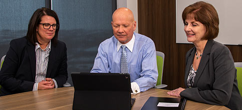 three people looking at a computer 