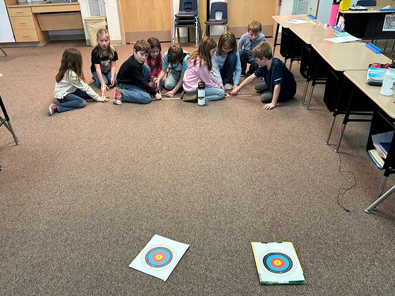 Children lined up with catapults.